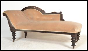 A late 19th century Victorian ebonised mahogany chaise longue - sofa day bed being raised on