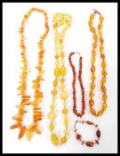 A group of five amber type necklaces consisting of a yellow bead necklace, baroque amber type