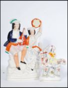 A Victorian Staffordshire flat back ceramic figurine of a goat and lady. Together with another