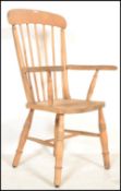 A Victorian beech and elm wood Windsor dining chair being raised on turned legs united by stretchers