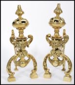 A pair of 19th century cast brass fireside dogs raised on block feet with scrolled legs. Grotesque