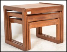A vintage / retro 20th Century teak wood nest of three graduating tables, square tops raised on