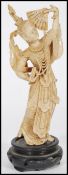 An early 20th Chinese century bone carved figure of a deity / Buddha with headdress and fan raised