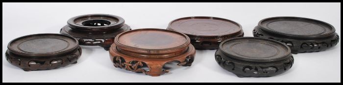 A selection of antique round wooden Chinese socle plinths - vase stands having pierced decoration to