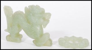 A Chinese Jade carved figurine of a dragon along with a carved jade bangle of typical form. Dragon