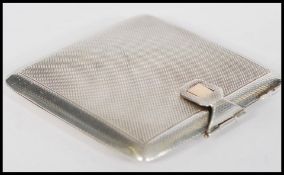 A hallmarked silver compact of square form having engine turned decoration with gold clasp.