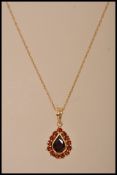 A stamped 9kt gold yellow metal pendant necklace with a twisted chain and a tear drop shaped pendant