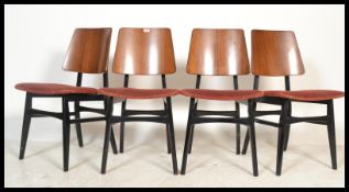A set of 4 mid century teak wood G-Plan dining chairs being raised on ebonised Librenza style legs