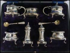 A cased seven piece silver hallmarked cruet set consisting of salt and pepper shakers /