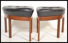A pair of mid century triangular stools being raised on tapering turned legs with black faux leather