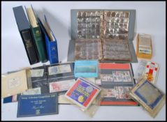 A large collection of vintage stamps FDC's, coins, cigarette cards etc to include albums of