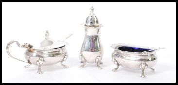 A 20th century hallmarked silver three piece condiment cruet set consisting of a tall pepperette,