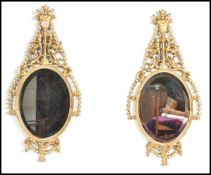 A pair of contemporary French baroque style oval wall mirrors with cast frames and a gilt ormolu