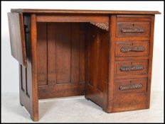 A 1920's oak childs Industrial style clerks desk with drop leaf to side, open kneehole recess