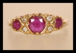 A hallmarked 9ct gold ruby and diamond ring having three rubies with diamond spacers.  Hallmarked