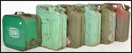 A collection of 20th century metal painted petrol gerry cans to include some with military crow's