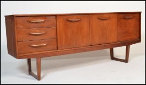 A 1970's / mid century teak wood sideboard credenza of Danish influence having angular legs with