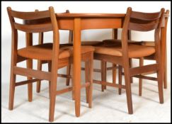 A retro 20th Century G Plan style oval extending teak wood dining table raised on shaped tapering