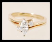 Two matching 14ct gold stacking rings of serpentine form, one set with a lozenge shaped diamond