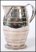 A 19th Century silver plated water jug with copper accents and banded decoration, with a