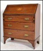 An Edwardian mahogany inlaid bureau desk having an appointed interior set within and with chest of