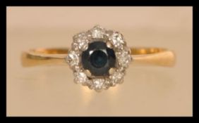 An 18ct gold diamond and sapphire ring having a central sapphire with a halo of diamonds. Weighs 2.9