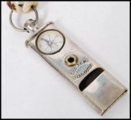 A vintage 20th century ACME girl guide whistle and compass compendium on string necklace. Measures