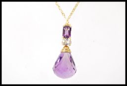 An 18ct gold pendant necklace having a large facted amethyst pendant drop with a smaller oval cut