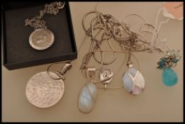 A selection of silver pendant necklaces to include a stamped 925 oval pendant with mother of pearl