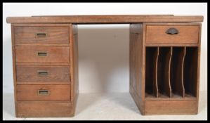 An early 20th century large oak partners desk being raised on twin pedestals with banks of drawers
