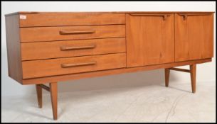 A 1970's Danish influence teak wood credenza sideboard raised on tapering legs having a bank of 4