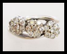An 18ct white gold triple cluster crossover ring h