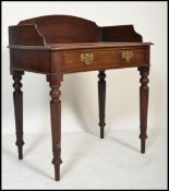 A Victorian 19th century solid mahogany writing table desk being raised on turned, tapering legs