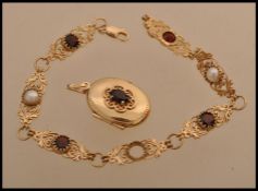 A hallmarked 9ct gold fancy link bracelet with inset red and pearlescent stones with scrolled