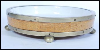 An early 20th century coopered oak barrel style wooden bound dog bowl, the wood secured with brass