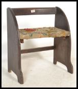 A 1930's oak dressing table stool of half moon shape with upholstered seat and arched panel back