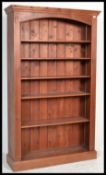 A large tall pine 6ft bookcase of upright form having a plinth base with central shelves and