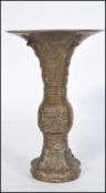 A 19th century Chinese bronze Gu vase of trumpet form raised on a circular base with Greek key and