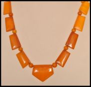 A vintage Art Deco amber bakelite necklace with yellow metal clasp. Large axe shaped panels with