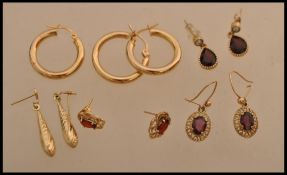 A selection of gold and yellow metal earrings to include a pair of stamped 375 gold hoop earrings, a