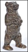 A 20th Century cast metal, cold painted money box, modelled as a Black forest bear standing on it'