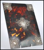 A 19th century Victorian tortoise shell blotter cover with ornate scrolled silver decorations to the