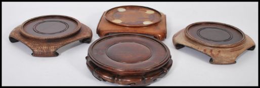 A group of four round wooden Chinese vase stands on four scrolled feet. Measures 20cm-wide 20cm-