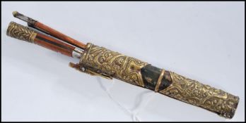 A 19th century Chinese Mongolian knife set having wooden handles with gilt brass decorated ends