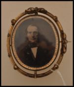 A large 19th century mourning brooch having a yellow metal case and sides with revolving central