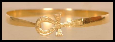 An 18ct gold Egyptian gold bangle bracelet having a Ankh hidden clasp. Egyptian hallmarks present to
