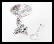 A silver salt in the form of a shell with a fish column and shell spoon. Weight 25.0g.