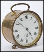 A 19th century Victorian brass alarm clock of round form with a white enamelled round face and roman