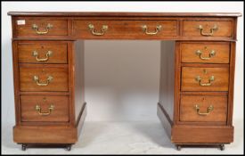 An Edwardian mahogany twin pedestal office desk being raised on squared plinth bases to each