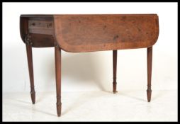 A Georgian 19th century mahogany inlaid pembroke / dining table being raised on turned legs with
